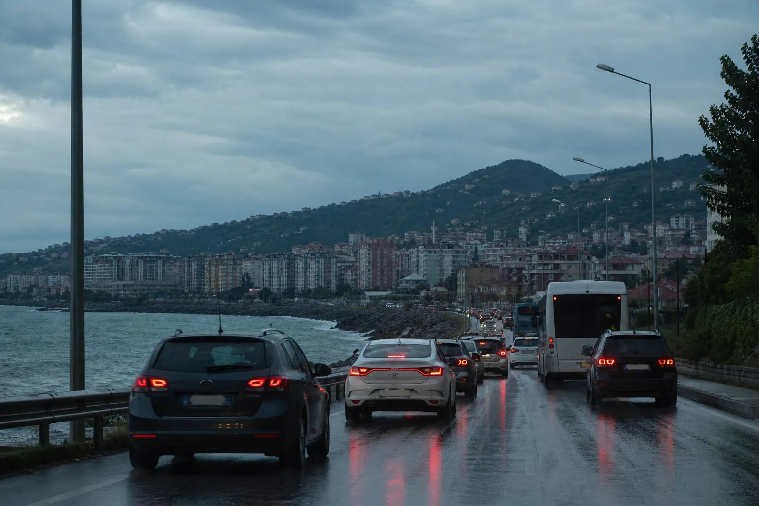 Yağmurlu öğleden sonra Trabzon sahil yolunda ıslak asfalt ve yavaşlayan araç trafiği